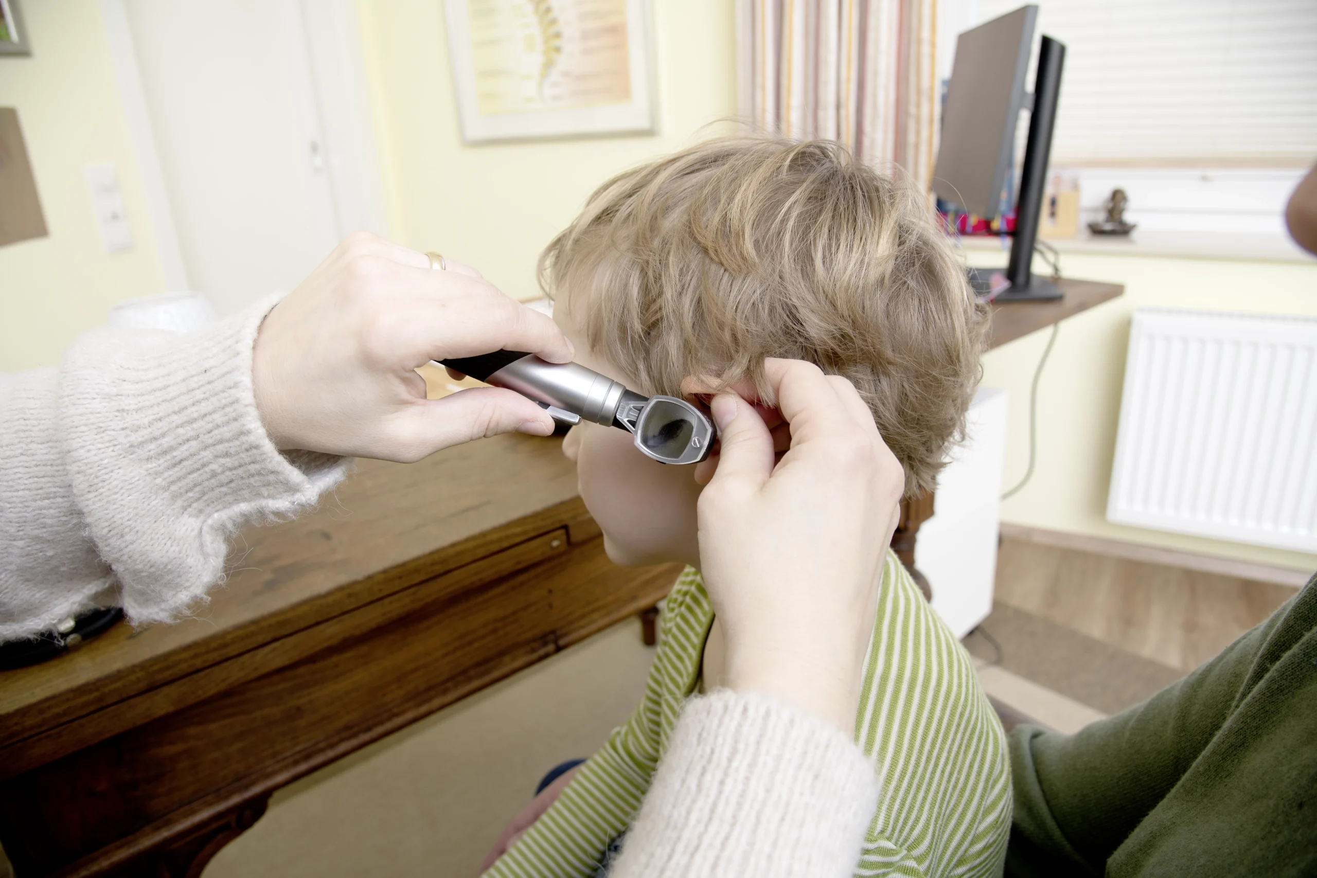 Kerstin schaut sich das Ohr eines Kinderpatienten genauer an