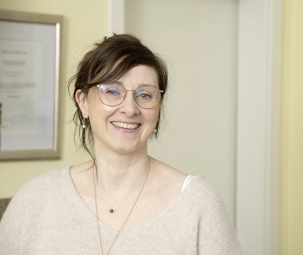 Kerstin Winner trägt eine Brille und lächelt in die Kamera